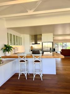a kitchen with two bar stools and a counter at Shorebreak Port Campbell in Port Campbell