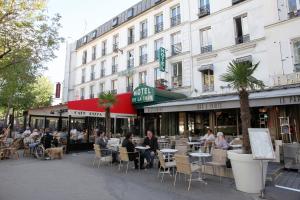 een groep mensen die aan tafels buiten een gebouw zitten bij Hotel de la Tour in Parijs