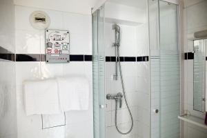 a bathroom with a shower, toilet, and sink at Hotel de la Tour in Paris