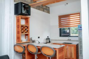 a kitchen with a counter and three chairs in a room at Kilistone Apartments in Uru