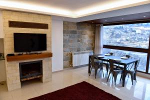a dining room with a table and a fireplace at Aspen - Duplex 1-BR in Faraya in Fārayyā