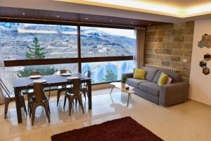 a living room with a table and a couch at Aspen - Duplex 1-BR in Faraya in Fārayyā