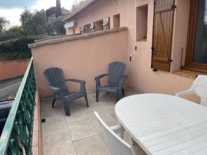 a patio with two chairs and a table on a balcony at L'Écrin de Sauge- jolie Terrasse in Gréoux-les-Bains +7 photos