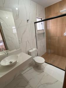 a bathroom with a toilet and a sink and a shower at Casa Portal Carrancas in Carrancas +10 photos