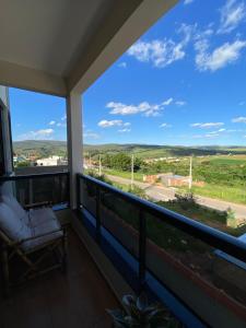 a balcony with a chair and a view at Casa Portal Carrancas in Carrancas