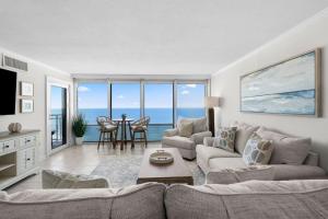 a living room with a couch and a table at New Beachfront Condo Pool Surfing Fishing in Virginia Beach