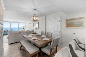 a dining room and living room with a table and chairs at New Beachfront Condo Pool Surfing Fishing in Virginia Beach