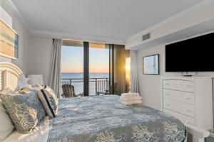 a bedroom with a large bed and a television at New Beachfront Condo Pool Surfing Fishing in Virginia Beach +69 photos