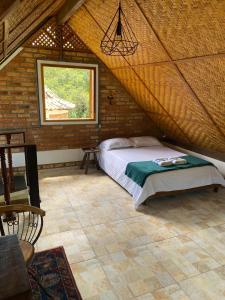 a bedroom with a bed in a room with a window at Chalé Ouro in Ouro Preto