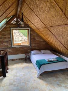 a bedroom with a bed in a room with a window at Chalé Ouro in Ouro Preto +4 photos