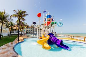 a water slide in a swimming pool next to the beach at El Aram Natal Mar in Natal