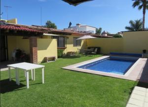 a backyard with a white table and a swimming pool at Rincones de Tequis in La Tortuga