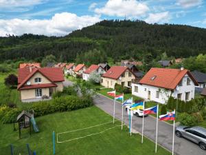 a row of houses with flags in a village at Villa Rezort Vlašky in Bešeňová