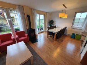 a living room with a table and a red couch at Villa Rezort Vlašky in Bešeňová
