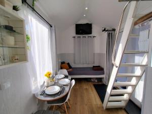 a small room with a dining table and a staircase at Koidula Tiny House in Narva-Jõesuu