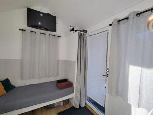 a bedroom with a bed and a tv on the wall at Koidula Tiny House in Narva-Jõesuu