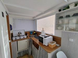 a small kitchen with a microwave on a counter at Koidula Tiny House in Narva-Jõesuu