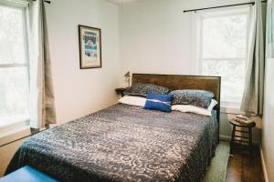 a bedroom with a bed and two windows at Charming Cottage w Hot Tub in Myers Airport