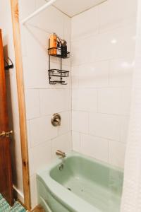 a green bath tub in a bathroom with white tiles at Charming Cottage w Hot Tub in Myers Airport +30 photos