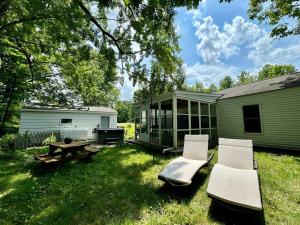 a backyard with a picnic table and chairs and a building at Charming Cottage w Hot Tub in Myers Airport