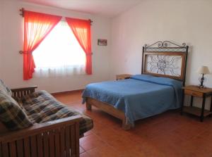 a bedroom with a bed and a couch and a window at Rincones de Tequis in La Tortuga +36 photos
