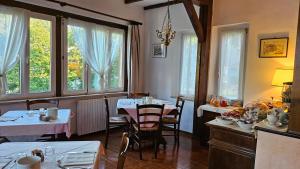 a dining room with tables and chairs and windows at Bellavista in Badia Prataglia