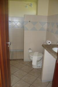 a bathroom with a toilet and a sink at Pousada Portal do Maragogi in Maragogi