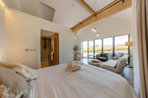 a bedroom with a large white bed and a living room at 1 Bed in Llanmorlais oc-p35002 in Penclawdd