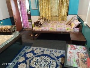 a living room with a bed and a rug at Bamboo Queen Homestay Rongo in Kumai