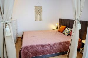 a bedroom with a bed with a purple comforter at Sophie Studio - Top center, Cozy & Work-Friendly near AUBG, Free streaming platforms in Blagoevgrad
