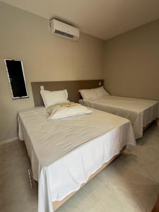 two beds in a hotel room with at Loft Brisas do Caeté in Bragança