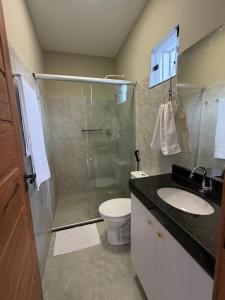 a bathroom with a shower and a toilet and a sink at Loft Brisas do Caeté in Bragança