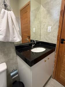 a bathroom with a sink and a mirror at Loft Brisas do Caeté in Bragança