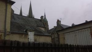 un viejo edificio con una valla delante en Appartement Dumas, en Bayeux