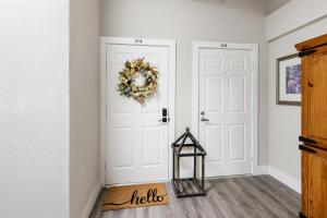 a hallway with a white door with a wreath at Stunning Apartment w Panoramic Downtown Views! in McKinney