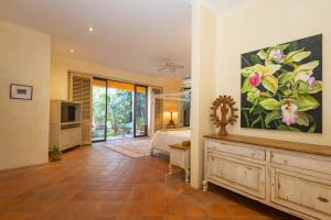 a bedroom with a large painting of flowers on the wall at Casa Tara Villa Oceanfront Oasis Private Beach in Cruz de Huanacaxtle