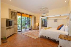 a bedroom with a bed and a television in a room at Casa Tara Villa Oceanfront Oasis Private Beach in Cruz de Huanacaxtle