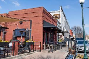 a brick building with tables and chairs on a street at Stunning Apartment w Panoramic Downtown Views! in McKinney
