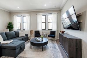 a living room with a couch and a tv at Stunning Apartment w Panoramic Downtown Views! in McKinney