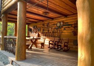 a porch of a wooden cabin with a table and chairs at Lisotel in Rokytne