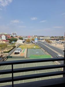 a tennis court in front of a city with a street at Prestige stays in Windhoek