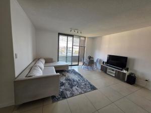 a living room with a couch and a flat screen tv at Prestige stays in Windhoek