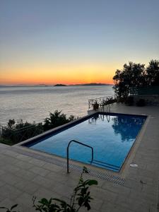 a large swimming pool with a view of the ocean at Villa Korina in Nea Epidavros
