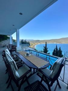 a table and chairs on a balcony with a view of the water at Villa Korina in Nea Epidavros