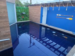 a bathroom with a shower with blue tiles at Casa luxo Maricá in Maricá