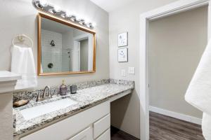 a bathroom with a sink and a mirror at Stunning Apartment w Panoramic Downtown Views! in McKinney +50 photos