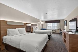 a hotel room with two beds and a flat screen tv at Best Western Timpanogos Inn in Lehi +53 photos