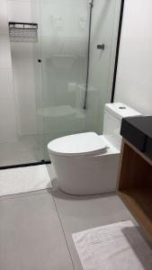 a white bathroom with a toilet and a shower at Apartamento Dein Haus in Pomerode
