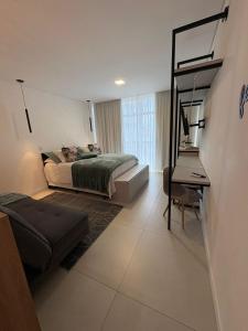 a bedroom with a bed and a desk in it at Apartamento Dein Haus in Pomerode