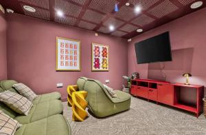 a living room with pink walls and a flat screen tv at The Parade - Cardiff - 10 Min Walk to City Centre in Cardiff